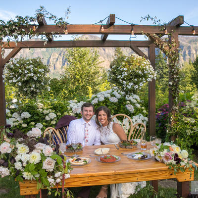 Newlywed couple sitting in arranged decorum in front of the restaurant