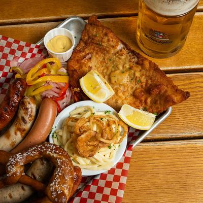 Bratwurst, schnitzel, sauerkraut, small pretzels, pickles, and mustard.