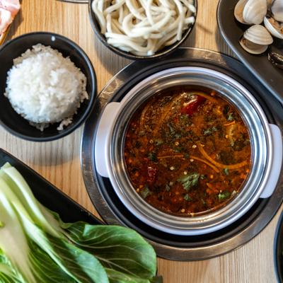 Broth with small white rice and noodle cups.
