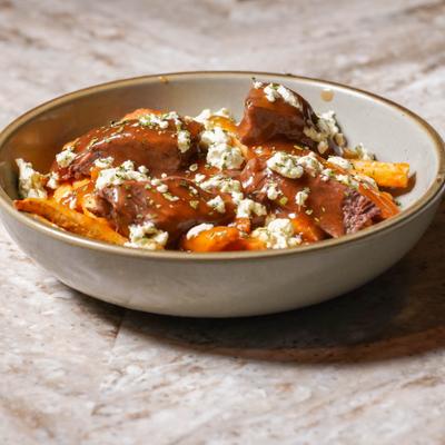 Poutine topped with gravy, slow-roasted beef and cheese.