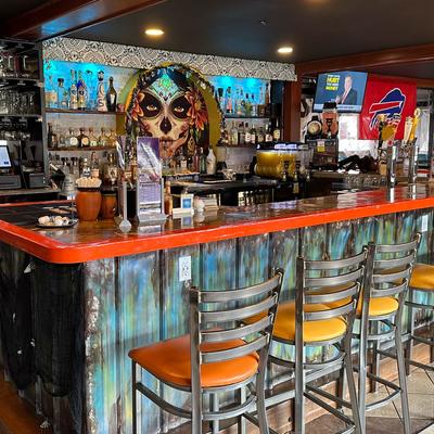 Interior, counter, chairs, register, bottles stacked on shelves, decorations