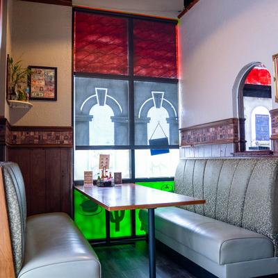 Light gray booth by the window with colorful shades.