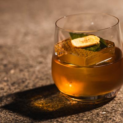 Her honey hand cocktail, served in a glass, front view.