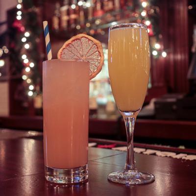 Two craft cocktails on a bar counter