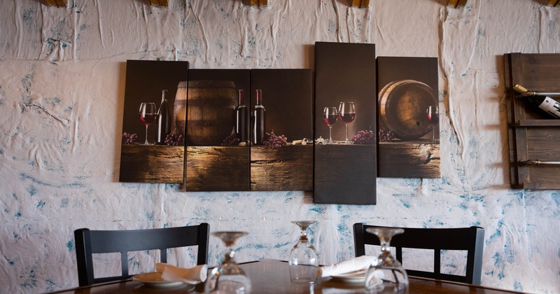 A table at the seating area, a wall decorated with a polyptych painting