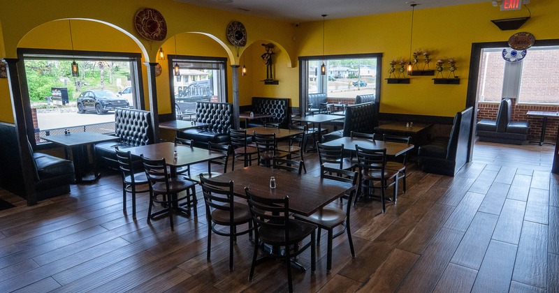 Cozy interior dining area with wooden tables and chairs, and upholstered booths