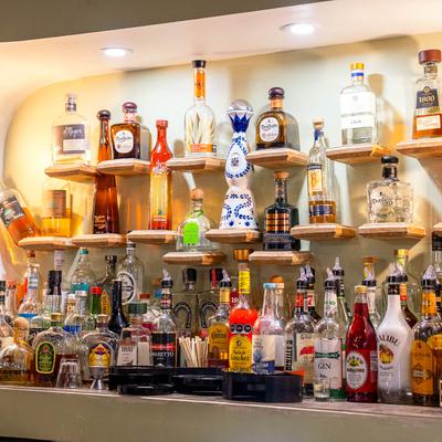 Assorted liquor bottles on bar shelves.