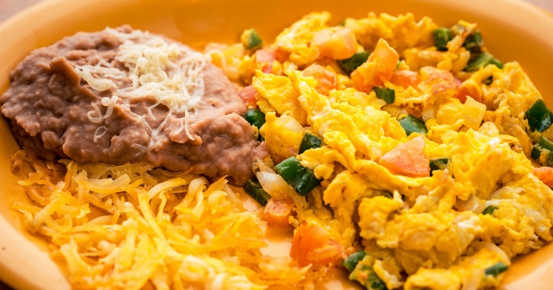 Mexican style scrambled eggs served with cheese and beans