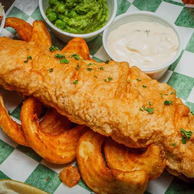 Pub style Fish and Chips, served with coleslaw, mushy peas, lemon, and tartar sauce.