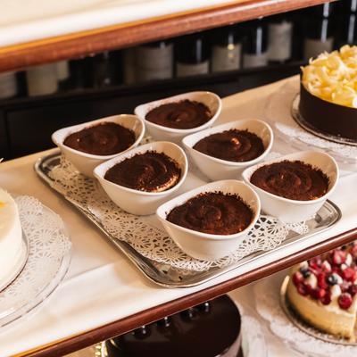Tiramisu desserts in white bowls on a tray.