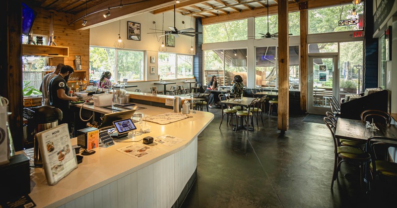 Interior, bar on the left side, tables with chairs in the back