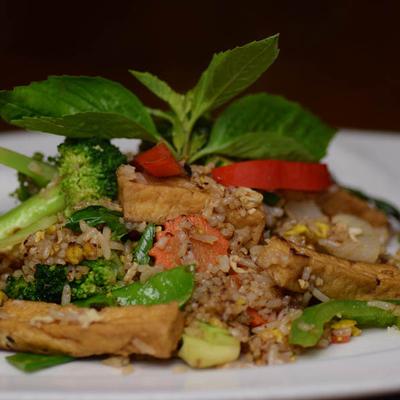 Tofu rice salad with veggies and mint garnish.
