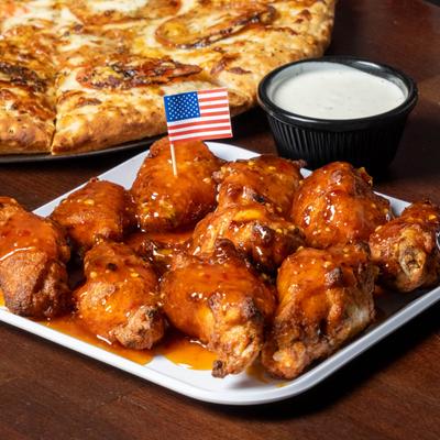 Spicy chicken wings with ranch sauce and a small American flag decoration.