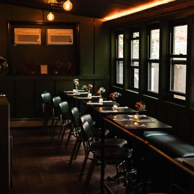 Interior featuring tables set with flowers and candles.