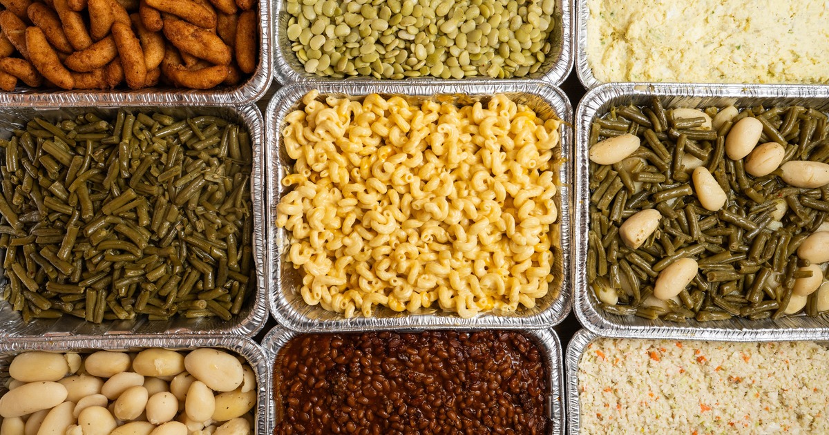 Numerus catering trays featuring various side dishes, overhead view