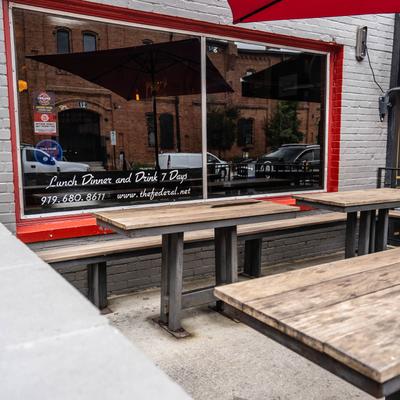 Outdoor seating with wooden tables and benches.