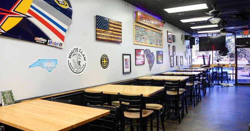 Interior, lined up dining tables by a wall with lots of decorations
