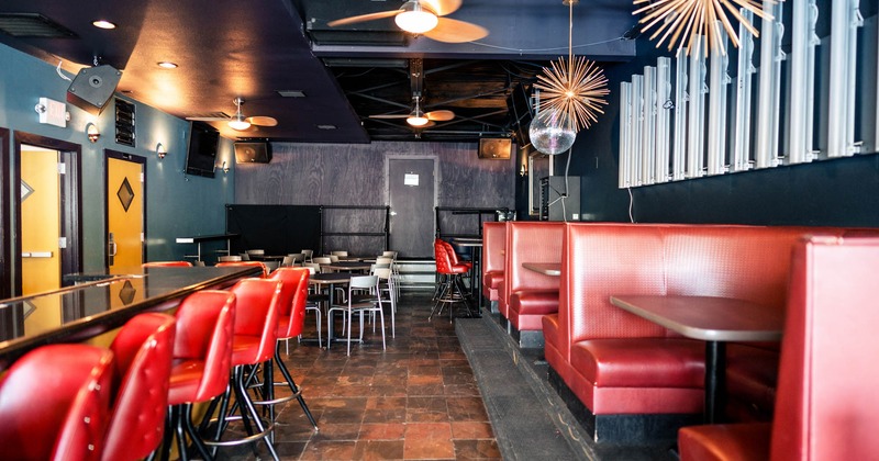 Interior, bar area, bar and bar stools on the left, seating booths lined up on the right