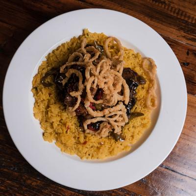 Asian Beef Tips served over saffron rice and topped with crispy onion straws.