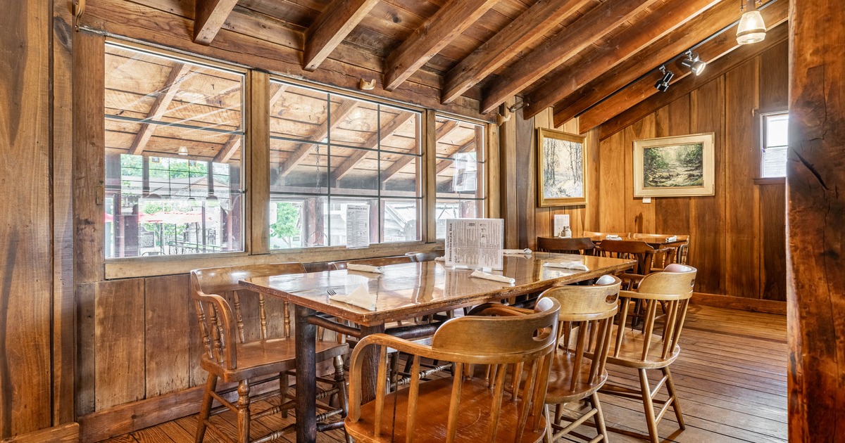 Interior, dining area, wooden tables for six and four, wooden walls and flooring, framed paintings