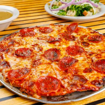 Thin Crust Pepperoni Pizza served alongside a salad.