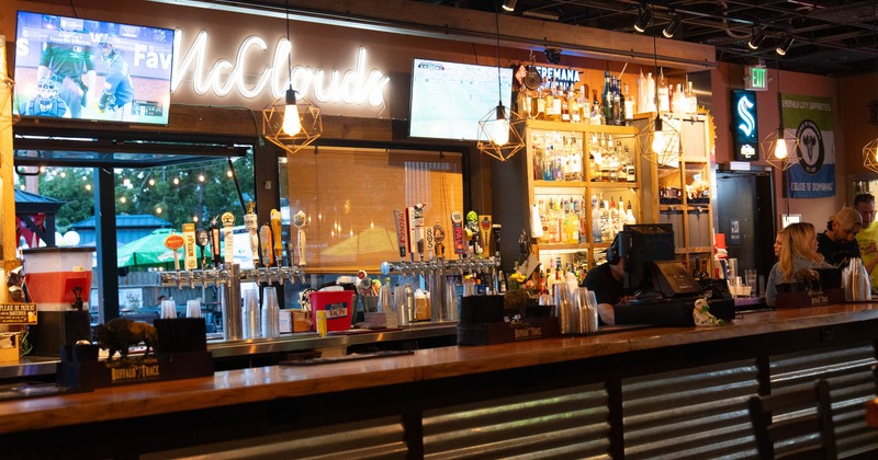Bar area featuring liquor bottles, beer taps, and TVs
