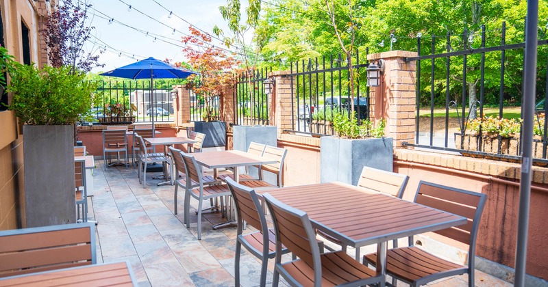 Exterior, patio, partially covered seating area, tables for four and two, lanterns