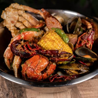 Cajun seafood boil with crawfish, lobster, mussels, and corn on the cob.