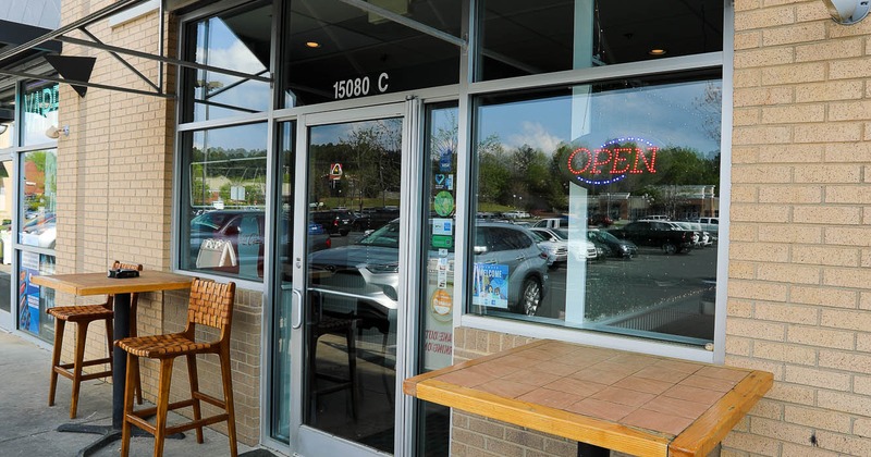 Exterior, high tables and chairs in front of main entrance