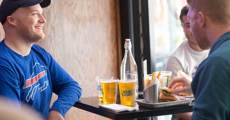 Patio, closeup of guests enjoying food and beer at a table