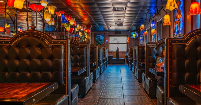 Interior of a restaurant with leather booths and colorful glass lamps resembling tulips