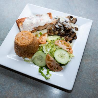 Salmon filet with creamy white sauce served with rice, mushrooms, and fresh salad.