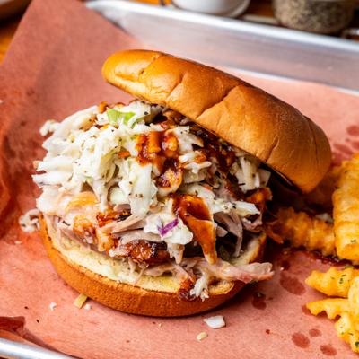 Memphis-style pulled pork sandwich served with crinkle-cut fries.