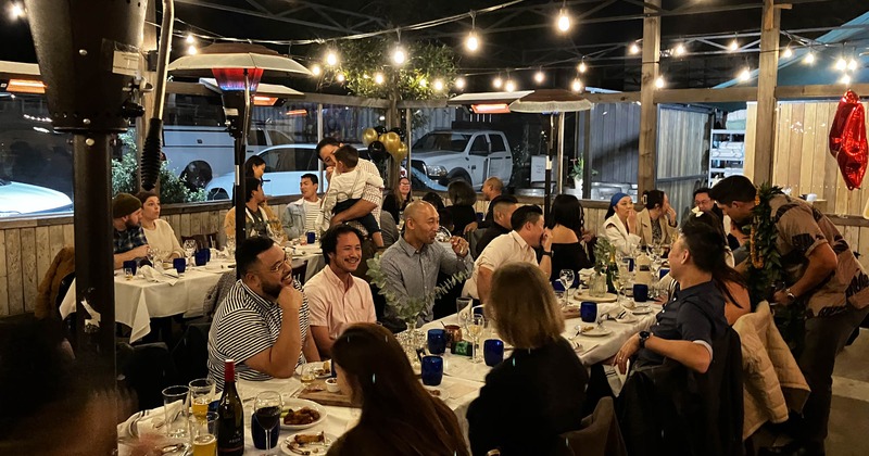 Guests enjoying a dinner party in an outdoor restaurant setting