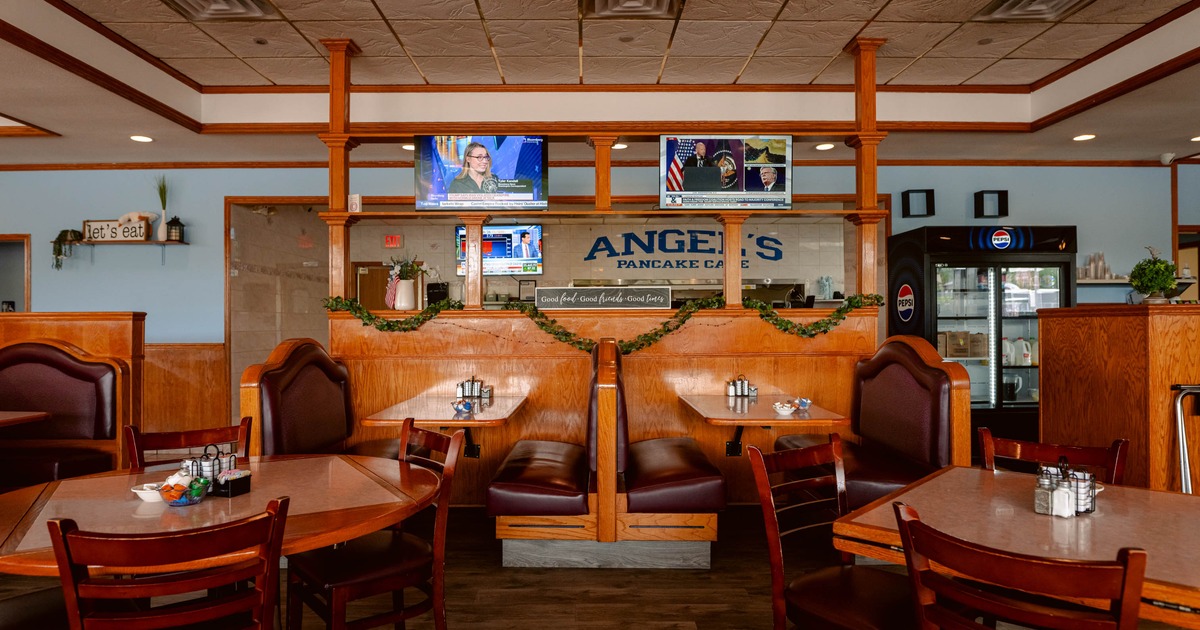 Interior, dining area, large seating booths for four, regular tables with wooden chairs