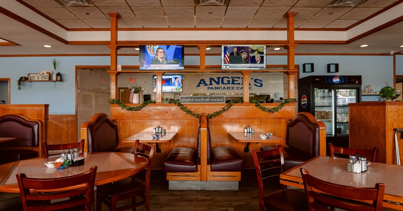 Interior, dining area, large seating booths for four, regular tables with wooden chairs