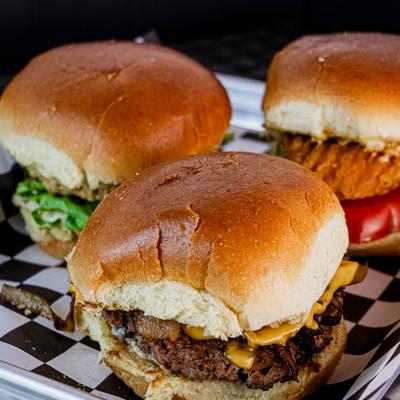 Three assorted burgers on checkered paper.