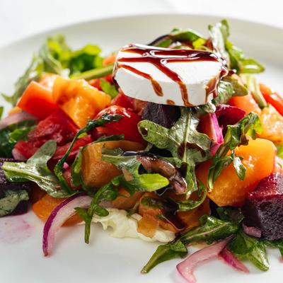 Salad with red and golden beets, tomatoes, red onion, goat cheese, EVOO, and balsamic glaze.