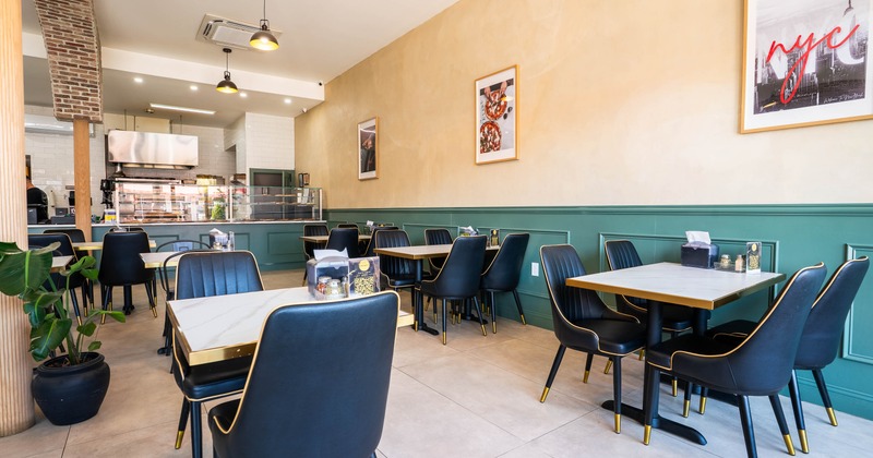 Bright, modern café interior with black chairs, white marble tables
