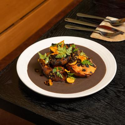 Roasted sweet potatoes entree, topped with various garnishes.