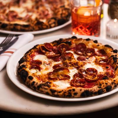 Pepperoni pizza served with a negroni cocktail.