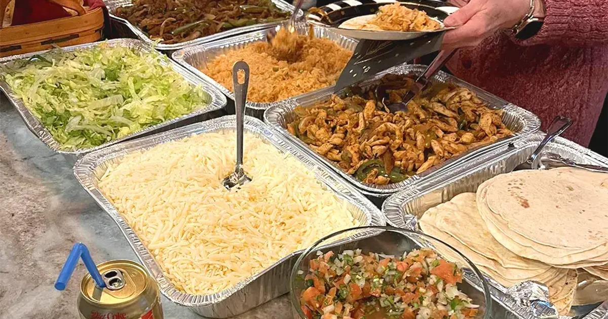 Person serving themselves from buffet trays