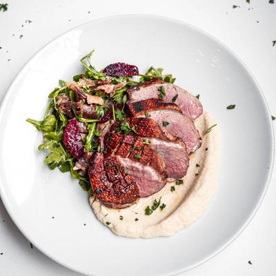 Roast beef on creamy mashed potatoes and arugula, overhead view