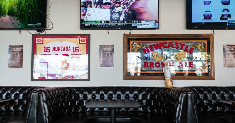 Interior, leather booth seating area, TV screens on the wall