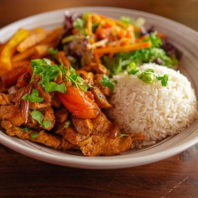 Stir fried chicken served with strips if vegetables over a bed of fries, with side of rice