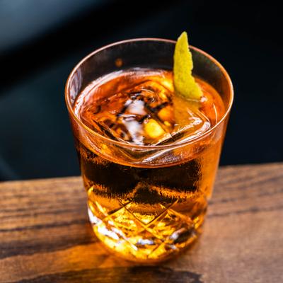 Old Fashioned cocktail with lemon peel garnish.