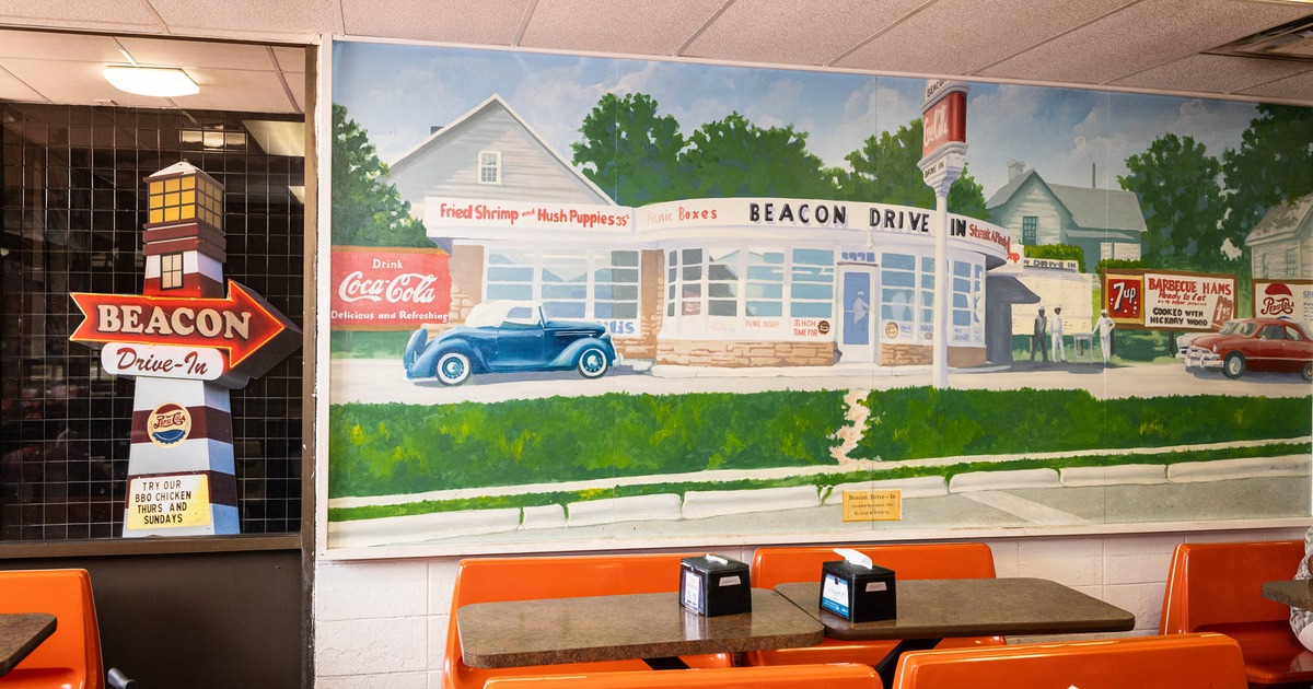 Interior of a diner featuring a colorful mural, light orange chairs and tables