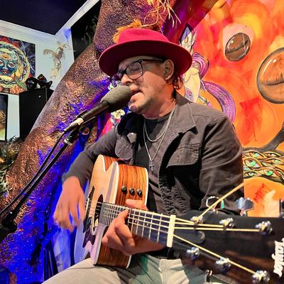 A person singing and playing the guitar.