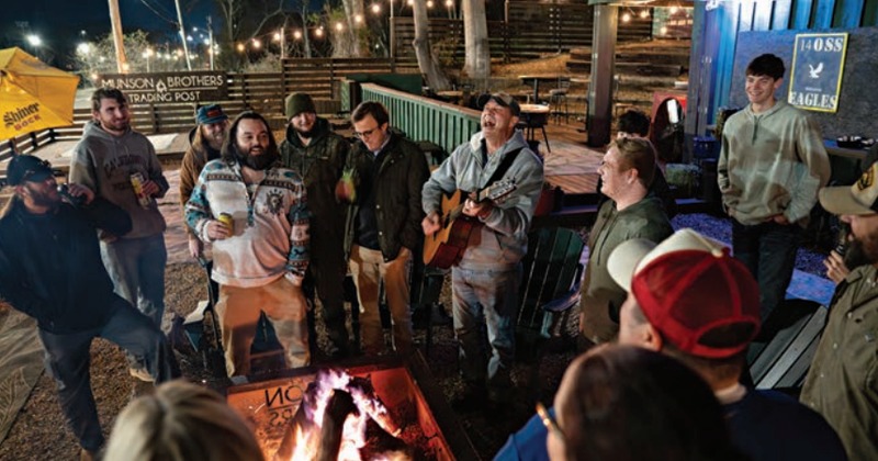 Group of people enjoying live music around a bonfire