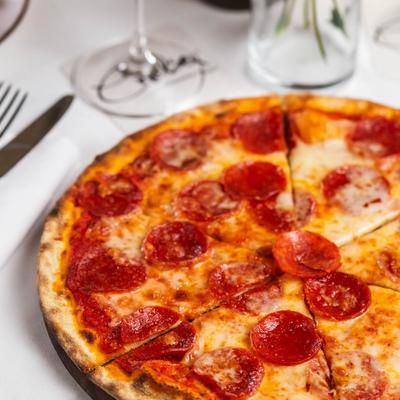 Pizza topped with mozzarella, tomato sauce, and spicy pepperoni.